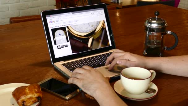 Hombre visita aliexpress sitio web utilizando MacBook Pro PC portátil en la cafetería — Vídeos de Stock