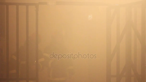 在一个封闭的、 黑暗的、 喷黑烟的房间里练习消防员 — 图库视频影像