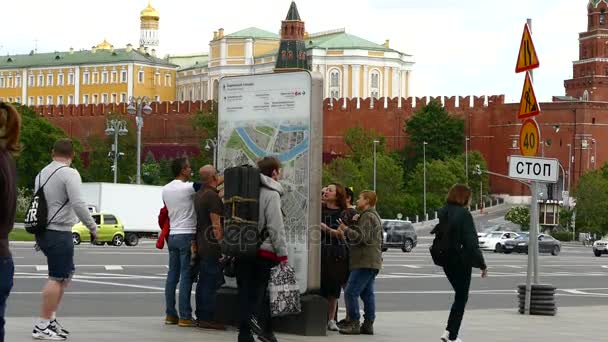 Ember után kutatnak egy információs standdal vesz részt a város térképe, a háttérben a Kreml — Stock videók