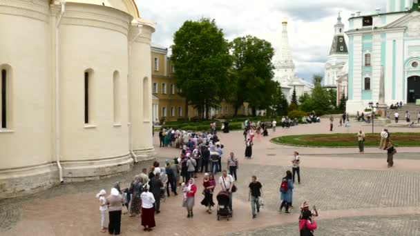 Tourists and pilgrims are walking in the square of Sergiev Posad, in the monastery of the Holy Trinity Sergius — Stock Video