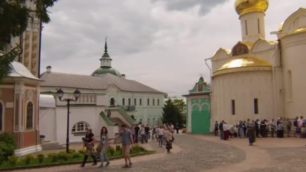 Tourists and pilgrims are walking in the square of Sergiev Posad, in the monastery of the Holy Trinity Sergius — Stock Video