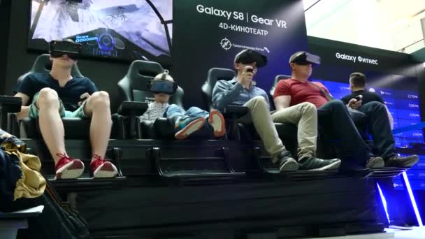 Pessoas com uma experiência imersiva de visualização de conteúdo VR no Samsung Gear VR Theater com cadeira 4D — Vídeo de Stock