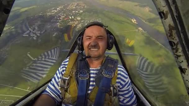 Hombre en la cabina de un avión llevando una figura acrobática — Vídeos de Stock