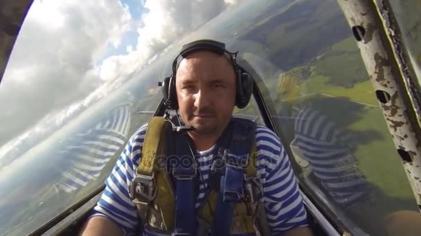 Hombre en la cabina de un avión llevando una figura acrobática — Vídeo de stock