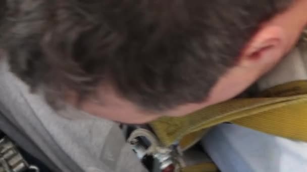 Pilote attachant sa ceinture de sécurité .