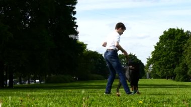 Çocuk parkta büyük bir köpek ile oynuyor