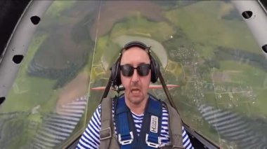 Akrobasi küçük Yakovlev 52 uçakta gerçekleştirirken aşırı yüklenme sahip adam.