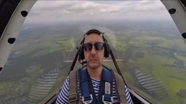 Gökyüzünde akrobasi uçağı kabinde oturan komik adam