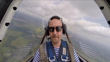 Gökyüzünde akrobasi uçağı kabinde oturan komik adam