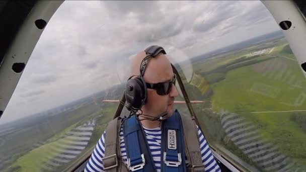 Uomo divertente seduto in cabina aerea acrobatica nel cielo — Video Stock