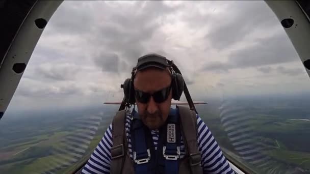 Lustiger Mann sitzt in Kunstflugzeugkabine am Himmel — Stockvideo
