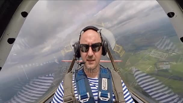 Забавный человек, сидящий в аэробатической кабине самолета в небе — стоковое видео