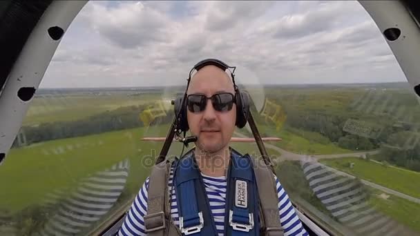 Grappige man zit in de cabine van het kunstvlieger vliegtuig in de lucht — Stockvideo