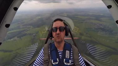 Akrobasi küçük Yakovlev 52 uçakta gerçekleştirirken aşırı yüklenme sahip adam.