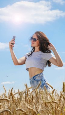 Cep telefonu ile güneş gözlüklü kız