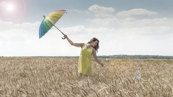 Frau mit Regenschirm im Feld — Stockfoto