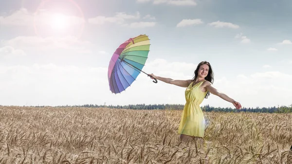 Vrouw met paraplu in het veld — Stockfoto