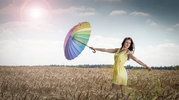 Kvinna med paraply i fält — Stockfoto