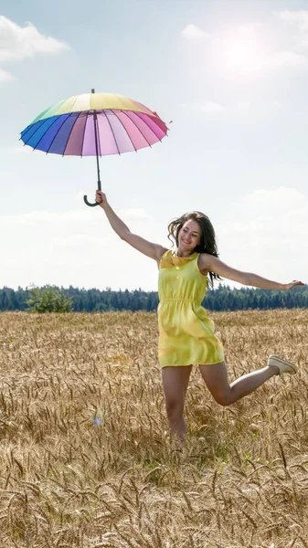 Vrouw met paraplu in het veld — Stockfoto