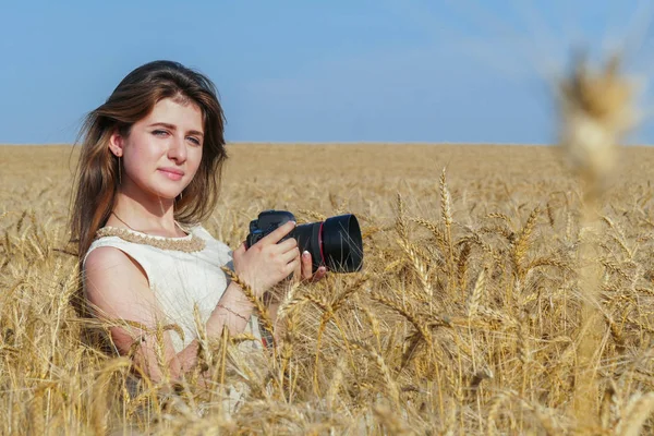 Vacker flicka att ta bilder med stor svart kamera på fältet — Stockfoto