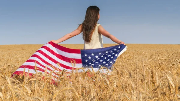 Vacker flicka med en USA flagga i fältet — Stockfoto
