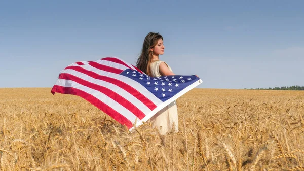 Vacker flicka med en USA flagga i fältet — Stockfoto