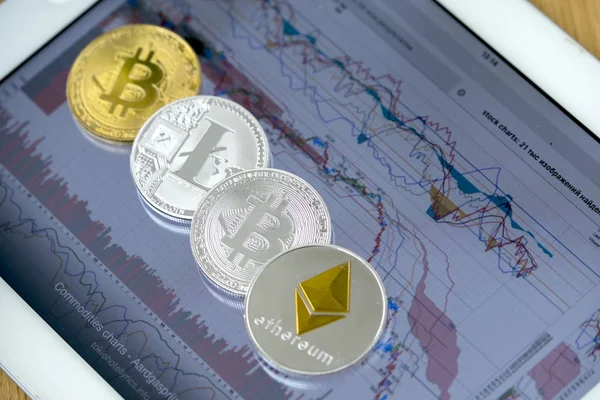 E-coins on tablet computer with charts on screen — Stock Photo, Image