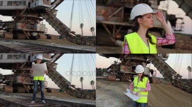 Kask içinde güzel kadın bir şey volki tolki tarafından büyük ekskavatör ile arka plan üzerinde tartışıyor