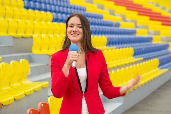 The journalist is reporting from the stadium for television