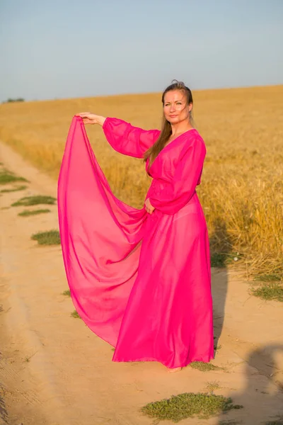 Porträtt av en ung sexig blond kvinna i grön klänning på en bakgr — Stockfoto