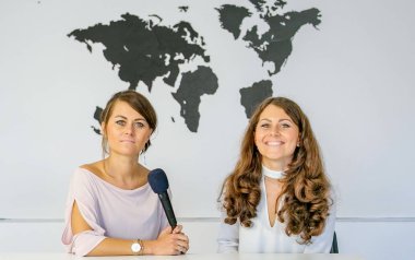 Gazeteci kamera önünde dünyanın büyük bir harita arka plan üzerinde raporlama.