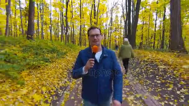 Μικρόφωνο στο χέρι δημοσιογράφοι περπάτημα σε Φθινοπωρινό δάσος. — Αρχείο Βίντεο