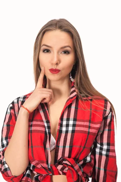 Cute funny blond girl with bun hairdo holding finger near lips — Stock Photo, Image