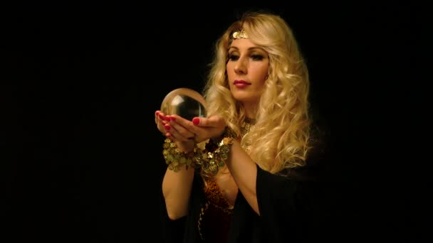 Belle astrologue blonde femme regardant à travers boule de cristal . — Video