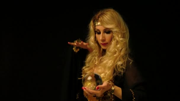 Όμορφη ξανθιά αστρολόγος γυναίκα ψάχνει μέσω κρυστάλλινη σφαίρα. — Αρχείο Βίντεο