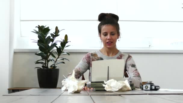 Joven escritora trabajando en máquina de escribir en habitación blanca con emoción positiva — Vídeos de Stock