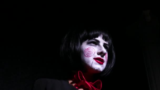 Portret młodej kobiety z przerażeniem, hallowing makijaż w stylu śpiewa piosenkę na ciemnym tle z bliska. — Wideo stockowe