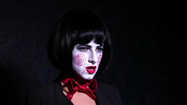 Portret młodej kobiety z przerażeniem, hallowing makijaż w stylu śpiewa piosenkę na ciemnym tle z bliska. — Wideo stockowe