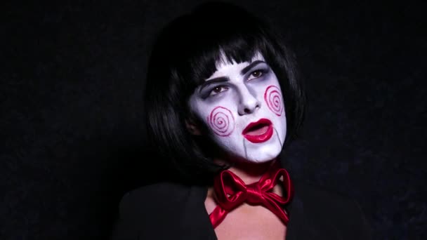 Close-up van portret van de jonge vrouw in horror, hallowing stijl make-up zingt een lied op donkere achtergrond. — Stockvideo