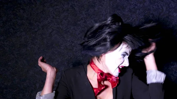 Mooie vrouw in horror stijl make-up zingt een lied op donkere achtergrond — Stockfoto