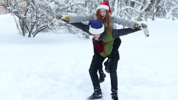 Pareja montando a cuestas en el invierno nevado — Vídeo de stock