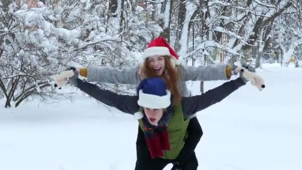 雪に覆われた冬のカップル ピギーバック乗馬 — ストック動画