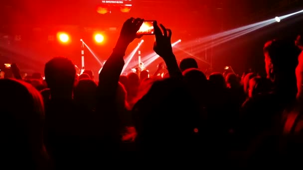 Kerumunan orang dalam sorotan lampu sorot di konser — Stok Video