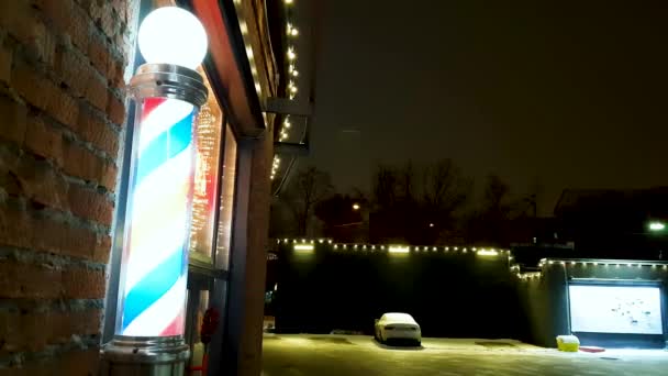 Bâton de coiffeur avec un moteur électrique tournant bande d'hélice de couleur rouge blanc et bleu enseigne commerciale montée sur le mur extérieur du magasin — Video