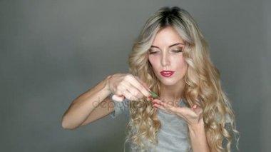 Onun gözlerinin içine eklemek için hazırlanan güzel bir sarışın elinde şeffaf bir kontakt lens.