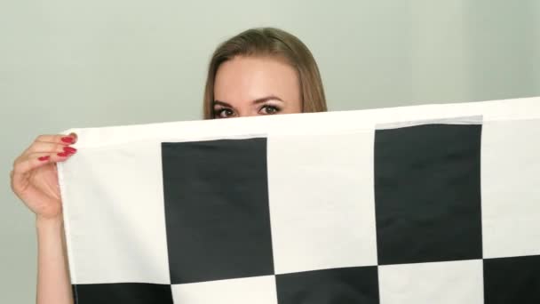 Mulher Está Segurando Uma Bandeira Xadrez Corrida Acenando Estúdio — Vídeo de Stock