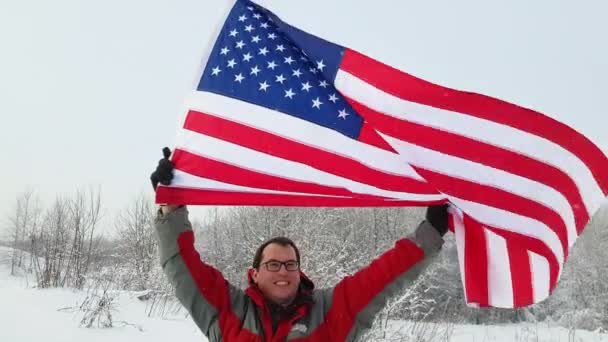 Человек с флагом США на лыжном склоне — стоковое видео