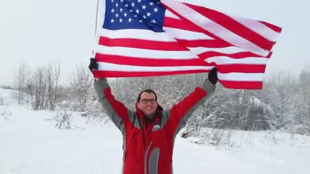 Hombre con bandera estadounidense en una pista de esquí — Vídeos de Stock