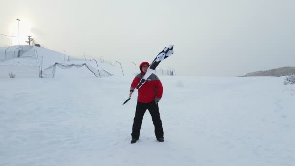 Uomo con bandiera di arrivo su una pista da sci — Video Stock