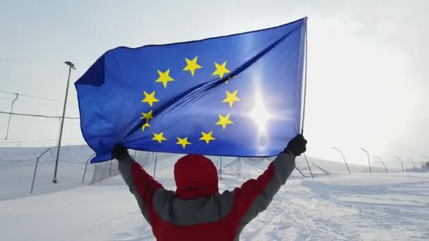 Hombre con bandera de la UE en una pista de esquí — Vídeos de Stock